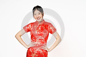 Asian woman wearing traditional cheongsam qipao dress standing with hands on waist and looking at camera isolated on white