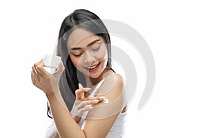 asian woman wearing white underdress using body cream rub into arm