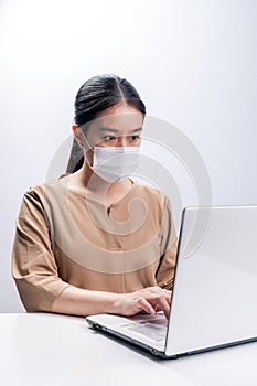 Asian woman wears protective mask working on white background