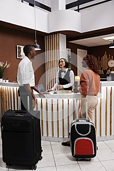 Asian woman welcoming couple at hotel