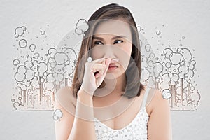 Asian woman in white dress catch her nose because of a bad smell