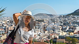 Asian woman in white t-shirt in Athens holding her hat photo