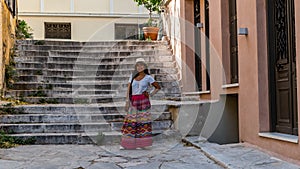 Asian woman in white t-shirt  in Athens in white hat and sarong standing in front of marble stairway photo