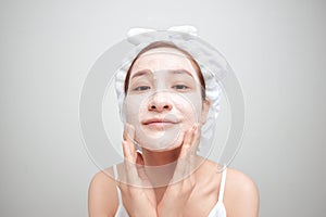 Asian woman in a white towel on her head with a mask on her face