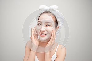 Asian woman in a white towel on her head with a mask on her face