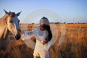 Asian Woman In White Walking Horse In Rural Field.