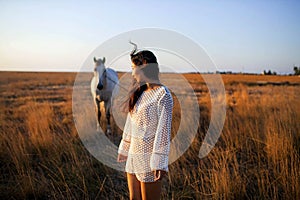 Asian Woman In White Walking Horse In Rural Field.