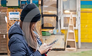 Woman in winter clothing is using Mobile phone for communication ourdoor photo