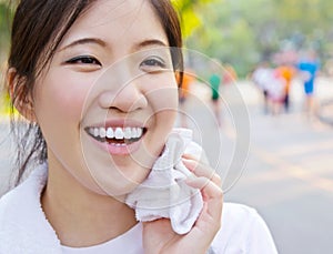 Asian woman wiping sweat with a towel