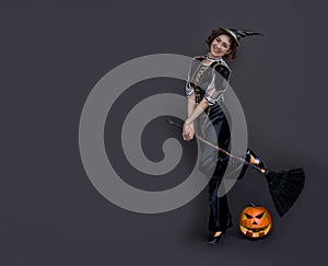 Asian woman with witch costume and old broom for halloween party concept on  background for advertising in hallowwen