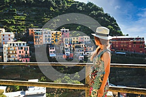 Asian woman woman looking at view of Riomaggiore village