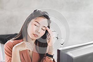 Asian woman worker suffering from eye pain tired from working on computer screen