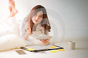 Asian woman working on the bed.