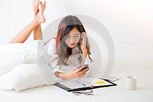 Asian woman working on the bed.