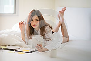 Asian woman working on the bed.