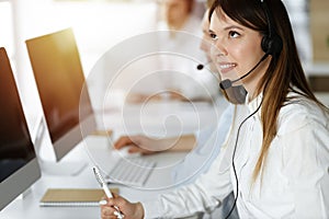 Asian woman working at customer service office. Business concept. Group of diverse operators at work in sunny call