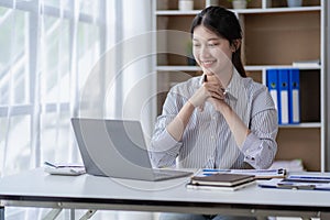 Asian woman working at home on desk using calculator to calculate tax accounting