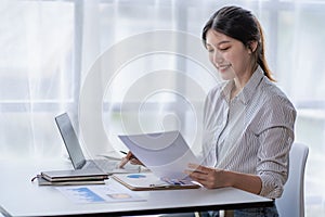 Asian woman working at home on desk using calculator to calculate tax accounting