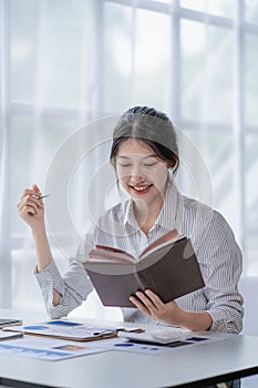 Asian woman working at home on desk using calculator to calculate tax accounting