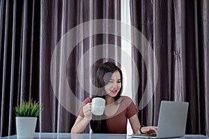 Asian woman working from home with laptop computer self isolation from society to reduce risk