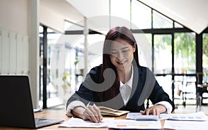 Asian woman working on a laptop computer,Working in the office with laptop concept,Young Asian woman starting a business