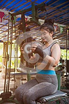 Asian woman working out with dumbbell weights at the gym.Fitness Women exercising are lifting dumbbells in gym.