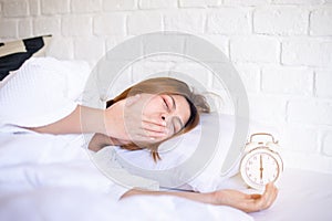 Asian woman yawning on bed and tired sleepy,Female having symptoms sleepiness