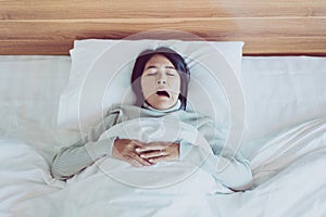 Asian woman yawning on her bedroom and tired sleepy,Symptoms and sleepiness photo