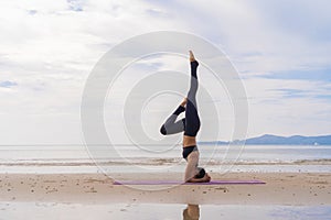 An Asian woman in yoga class club doing exercise and yoga at natural beach and sea coast outdoor in sport and recreation concept.