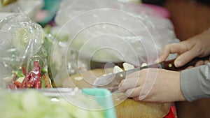 Asian womans hands shredding garlic at a market in bangkok