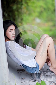 Asian womansitting outdoor in countryside. Young smiling woman outdoors portrait.