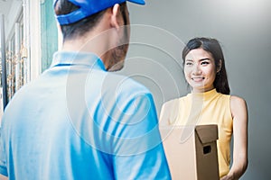 Asian woman accepting receive a delivery of boxes from delivery asian man photo