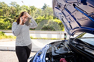 Asian women calling for assistance after breaking down car engine