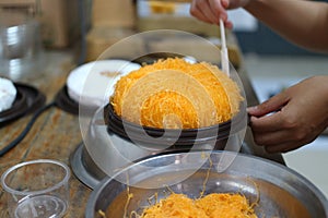 Asian women chefs are making colorful fios de ovos cakes, Thai style cakes. photo