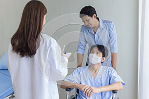 An Asian woman doctor is checking and talking with a man patien