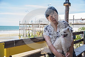 Asian women and dog at beach and sea when travel