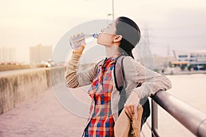 Asian women drinking water during backpacker relax time on vacation hipster lifestyle