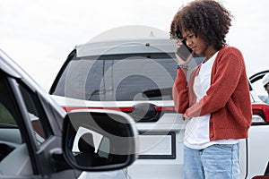 Asian women driver check for damage after a car accident before taking pictures and sending insurance. Online car accident