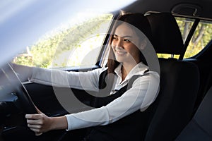 Asian women driving a car and smile happily with glad positive expression during the drive to travel journey.