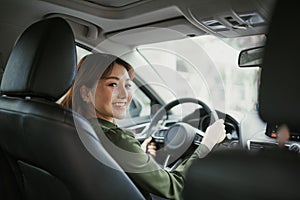 Asian women driving a car and smile happily with glad positive expression during the drive to travel journey