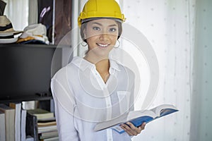 Asian women engineering inspecting and working and holding blueprints at home office