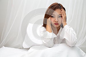 Asian women with feelings of helplessness and hopelessness on white bed in bedroom. photo