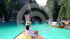 Asian women in front of a longtail boat at Kho Phi Phi Thailand