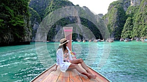 Asian women in front of a longtail boat at Kho Phi Phi Thailand