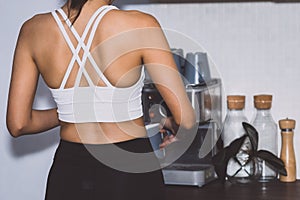 Asian women in gym clothes making coffee in Kitchen
