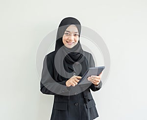 Asian women hand hold digital tablet look at camera with smile on gray backgroound