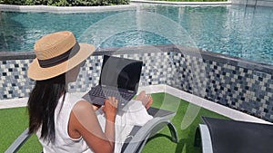 Asian women with hat checking laptop on holiday vacation, digital nomad concept