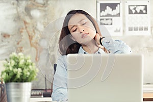 Asian women have neck pain from work in the office