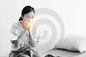 Asian women have stress due to the corona virus or covid19 sitting on the bed and covering their hands with their mouth to prevent