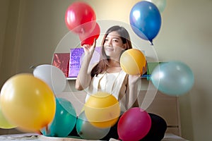 Asian women are having fun at home in bedroom with colorful balloons